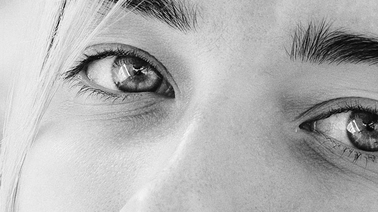 A close-up black and white portrait of a woman's eyes