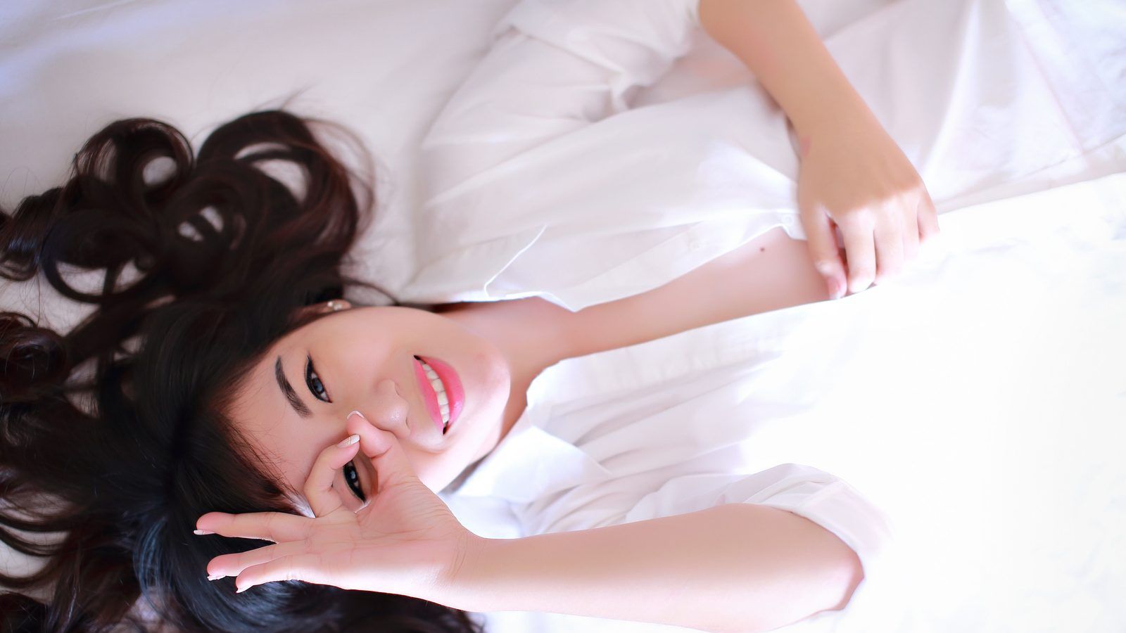 A relaxed portrait of a woman in a white shirt
